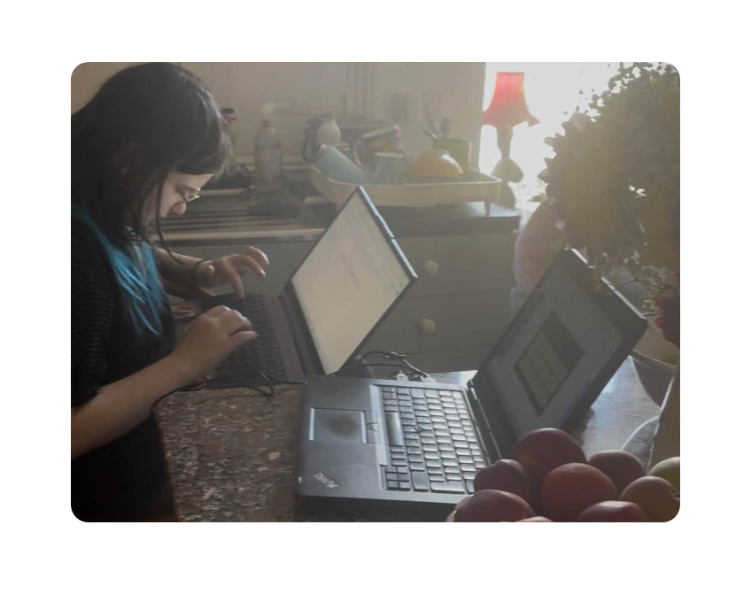 A young person working at a laptop at home